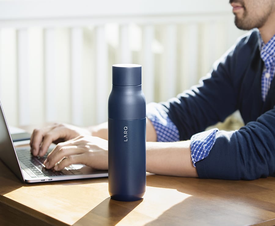 Larq bottle on a wooden table with laptop